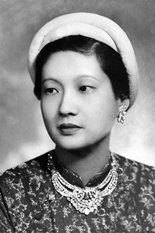Hoàng hậu Nam Phương mặc áo dài cổ truyền, đầu chít khăn vành
