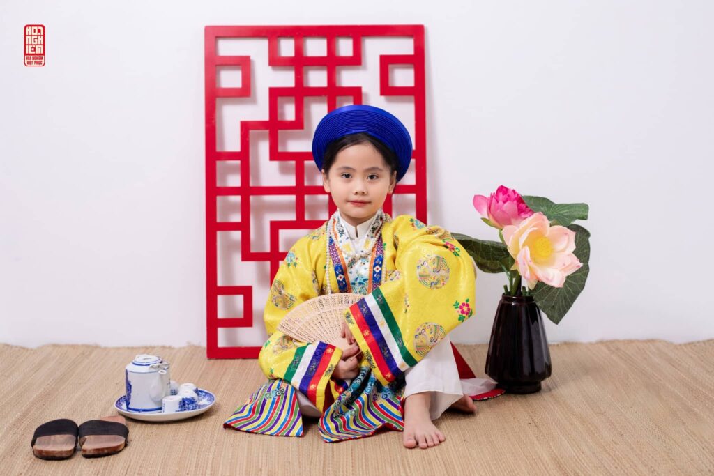 Bé gái mặc áo Nhật Bình màu vàng truyền thống chụp ảnh Tết tại Hoa Nghiêm Việt Phục Huế
