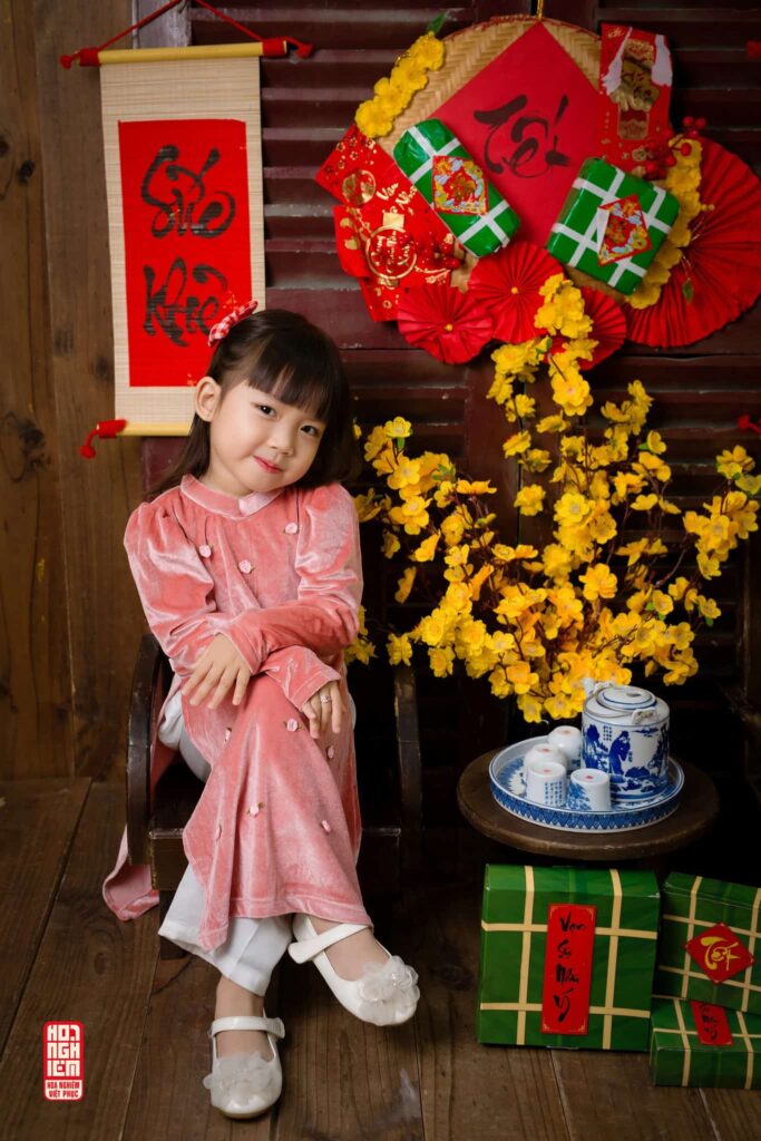 Bé gái mặc áo dài hồng truyền thống chụp ảnh Tết tại Hoa Nghiêm Việt Phục Huế