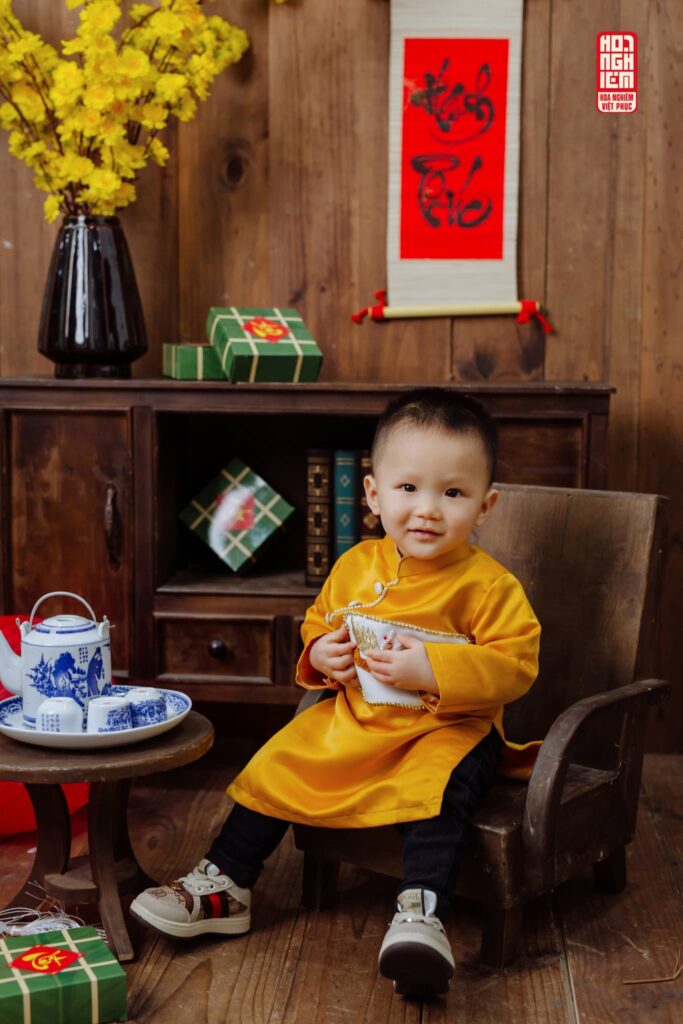 Bé mặc áo dài vàng truyền thống chụp ảnh Tết tại Hoa Nghiêm Việt Phục Huế