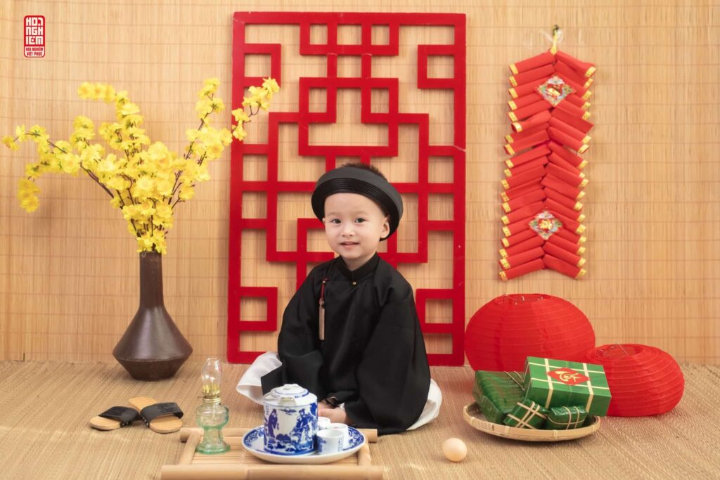 Bé trai mặc trang phục truyền thống màu đen chụp ảnh xuân tại Hoa Nghiêm Việt Phục Huế