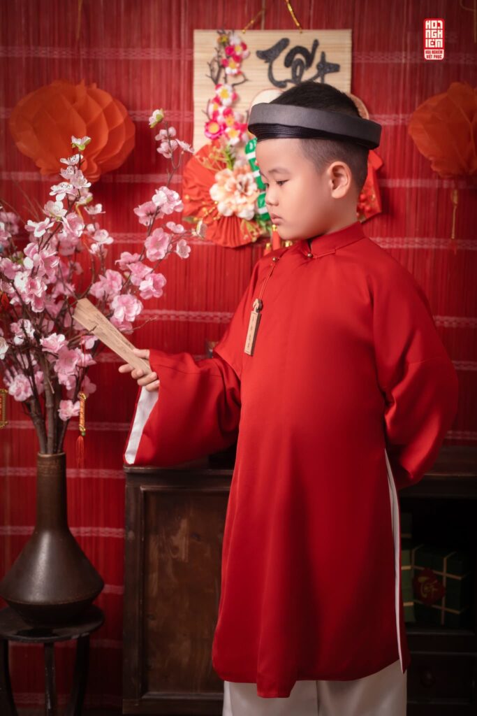 Bé mặc áo tấc đỏ truyền thống chụp ảnh Tết tại Hoa Nghiêm Việt Phục Huế
