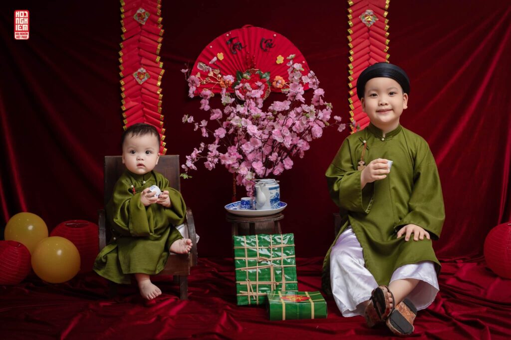 Bé trai mặc áo tấc xanh chuối truyền thống chụp ảnh Tết tại Hoa Nghiêm Việt Phục Huế