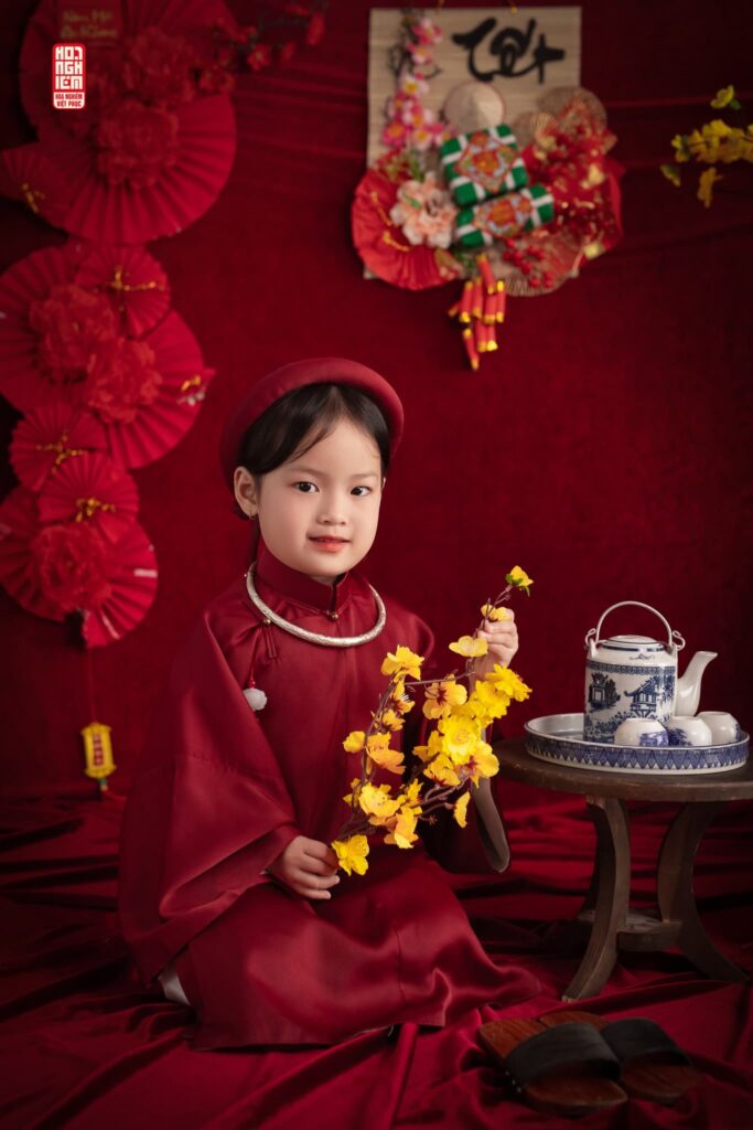 Bé gái mặc cổ phục màu đỏ mận chụp ảnh Tết tại Hoa Nghiêm Việt Phục Huế