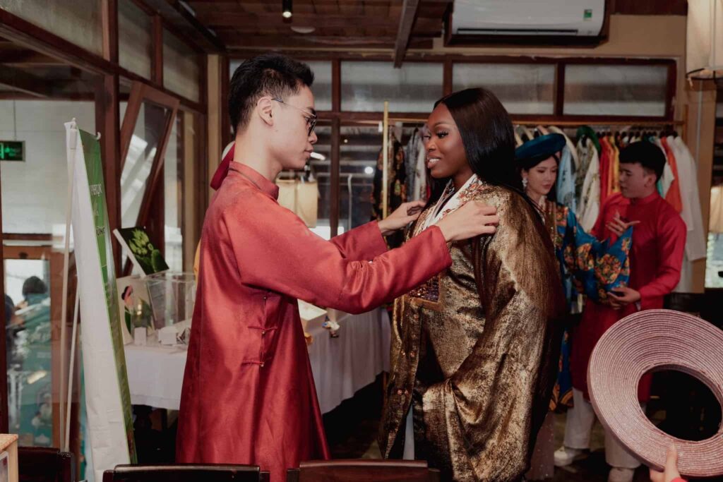 Nhân viên Hoa Nghiêm Việt Phục chỉnh sửa trang phục cho thí sinh Miss Cosmo 2025