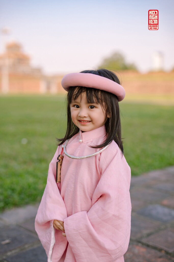 Bé gái mặc áo tấc hồng truyền thống chụp ảnh xuân tại Hoa Nghiêm Việt Phục Huế