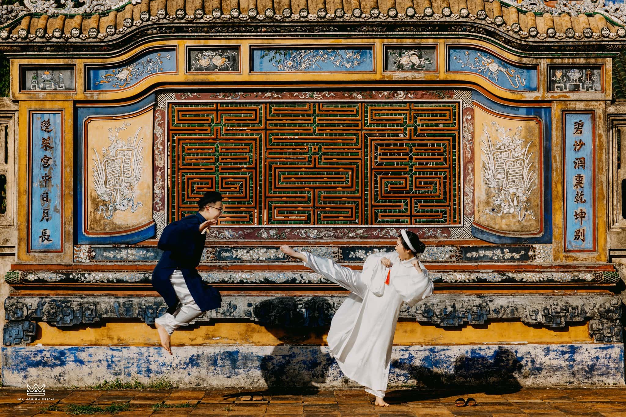 Cổ phục đôi Song Tấc Thanh Bạch với áo Tấc nam xanh chàm và áo Tấc nữ trắng trong khoảnh khắc vui nhộn trước bình phong cung đình