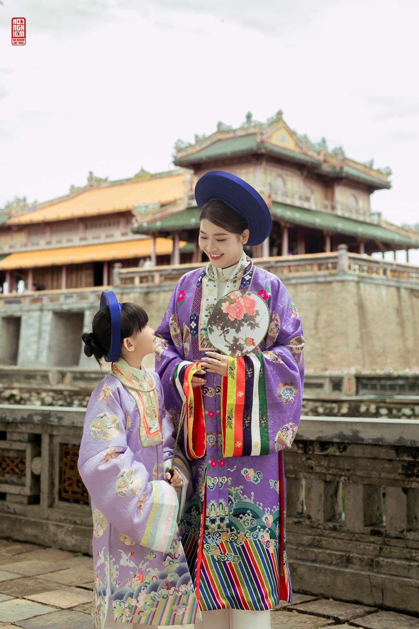 Mẹ và con gái mặc áo Nhật Bình tím nhìn nhau đầy tình cảm tại cung đình Huế