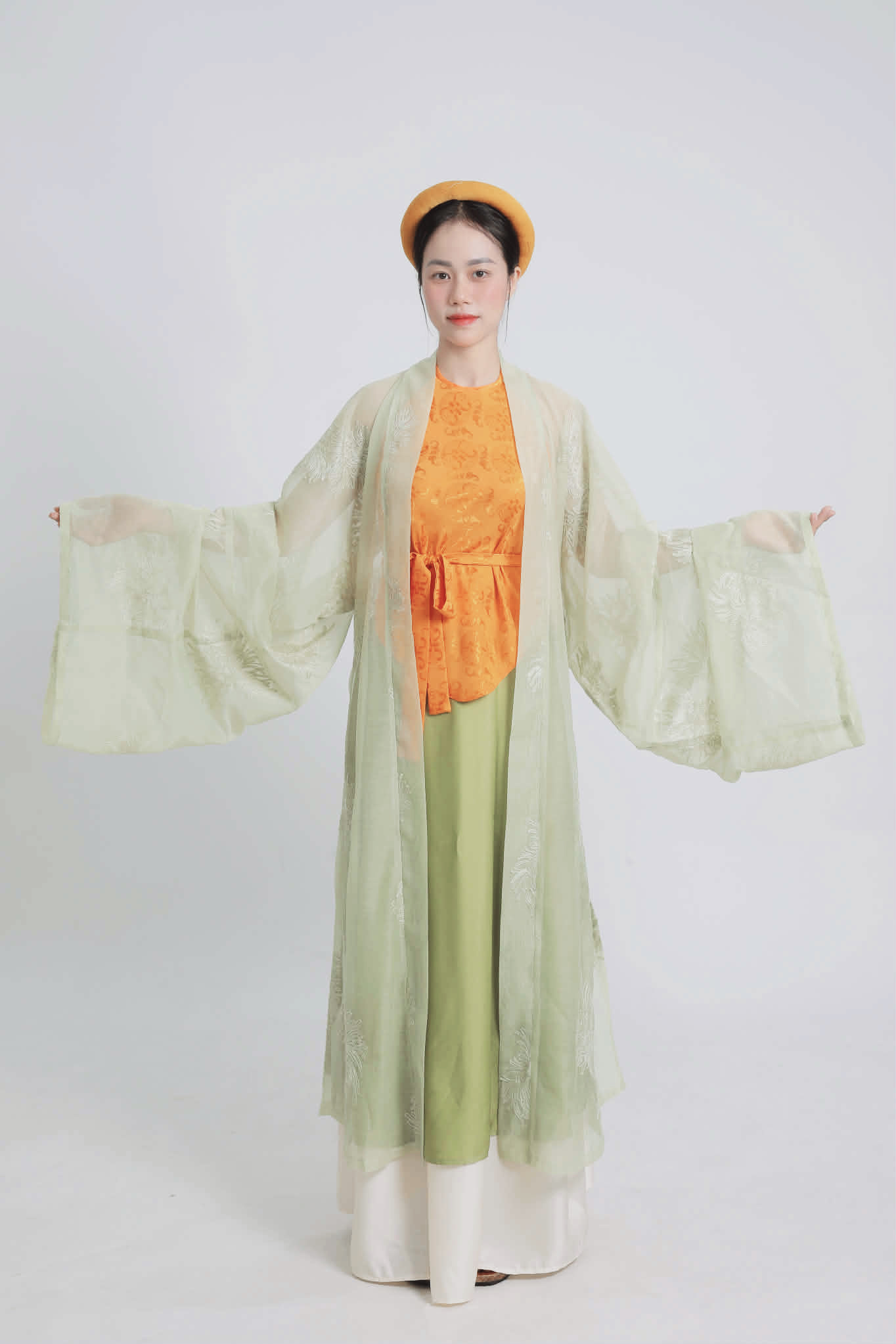 Việt phục cách tân Yếm khoác Đối Khâm – full set trên người mẫu Việt phục cách tân Yếm khoác Đối Khâm phối màu xanh cam thanh lịch, lấy cảm hứng Cổ phục Huế, thiết kế mềm mại, bay bổng.