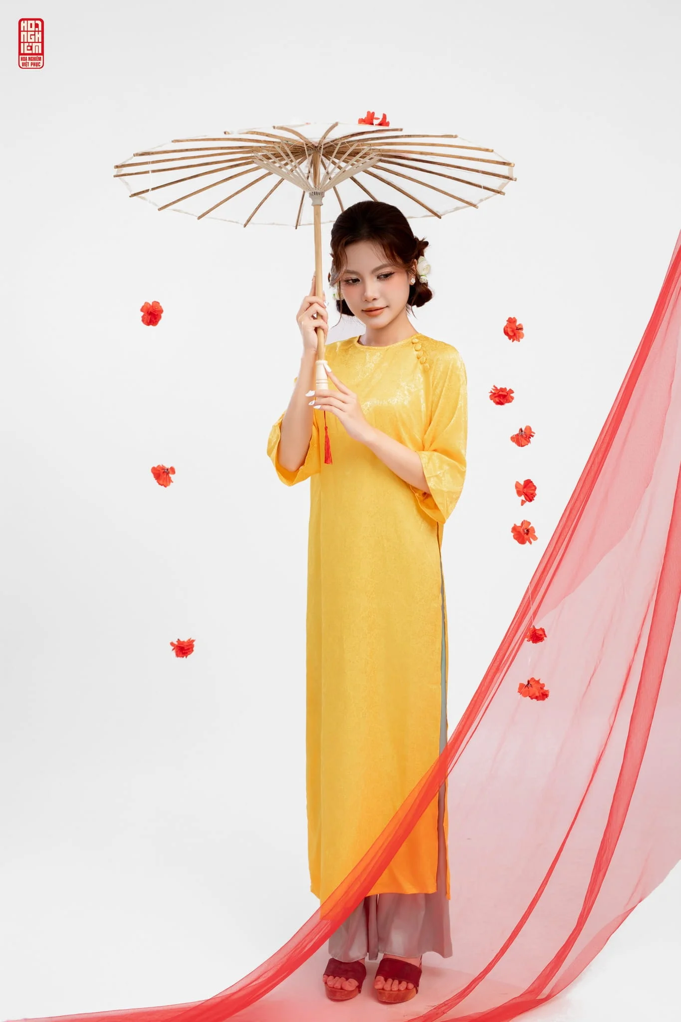 Áo dài lụa cách tân cổ tròn cúc bọc chéo vai màu vàng kết hợp ô giấy mang vẻ đẹp truyền thống Áo dài Huế.