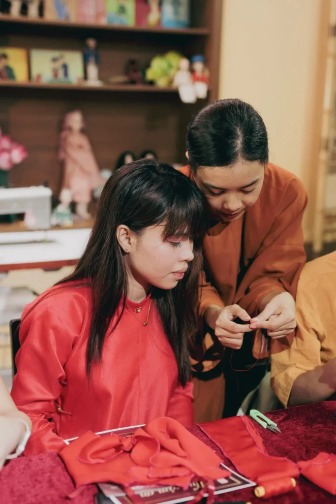 Khách tham gia tự tay may áo Ngũ Thân mini dưới sự hướng dẫn của đội ngũ nhân viên Hoa Nghiêm Việt Phục