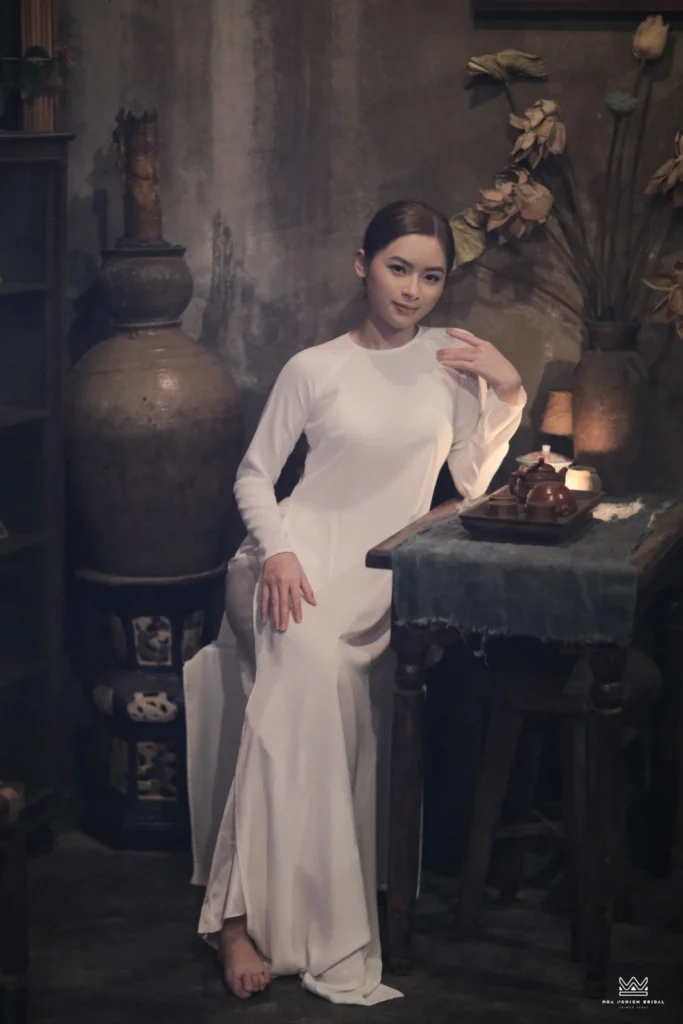 Ảnh áo dài trắng trong không gian Huế xưa mang phong cách trầm mặc và nghệ thuật, phù hợp cho chụp ảnh cổ phục Huế và trải nghiệm photography tour tại Huế.